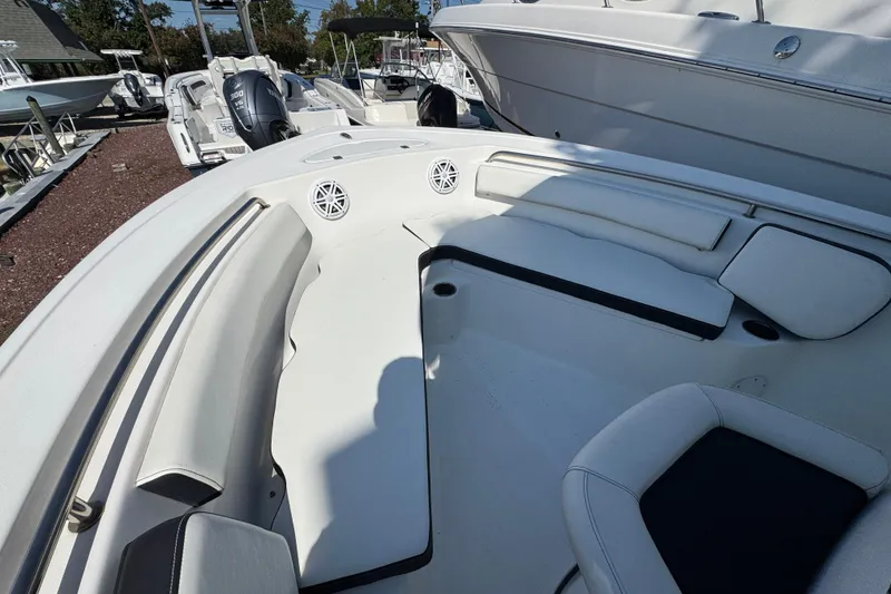 Slide: The Image of 2021 Tidewater 210 CC Adventure boat interior with white seating and speakers. - 23