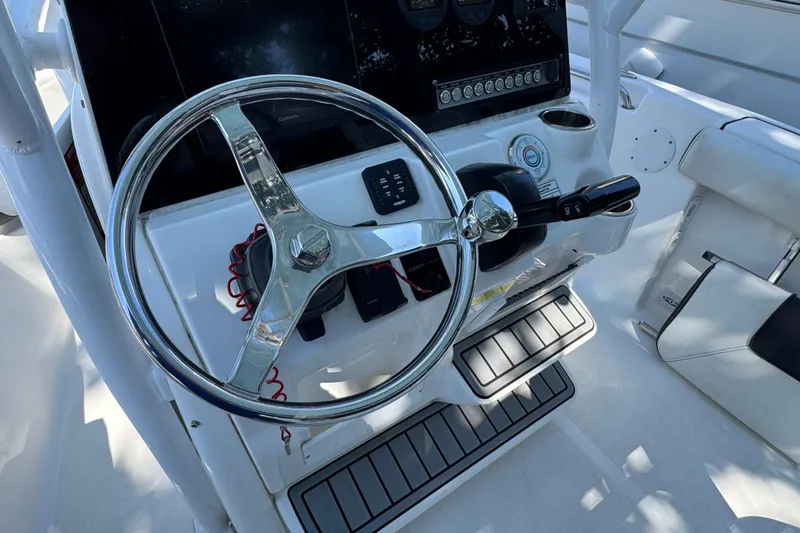 Slide: The Image of 2021 Tidewater 210 CC Adventure boat helm with steering wheel and controls. - 4