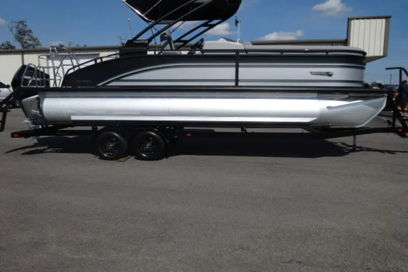 The Image of 2026 Harris Solstice 250 pontoon boat on trailer, parked outdoors under clear sky. - 0