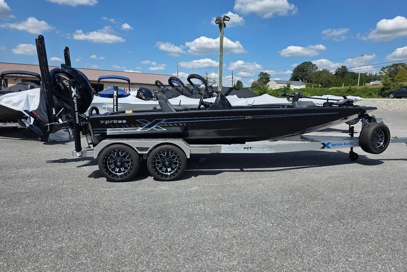 Slide: The Image of 2026 Xpress X21 Pro boat on trailer under clear blue sky. - 1