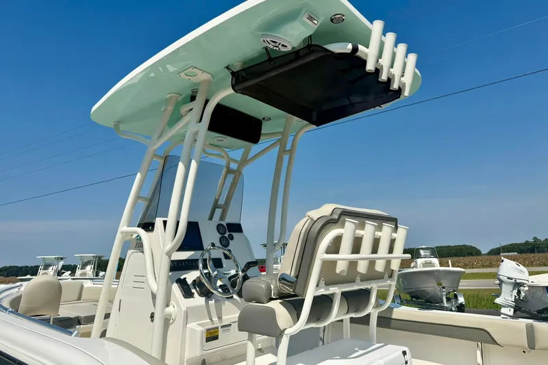 Slide: The Image of 2026 Key West 219 FS boat console with seating and rod holders under clear blue sky. - 12