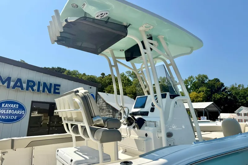 Slide: The Image of 2026 Key West 219 FS boat with T-top and console, displayed at a marine dealership. - 13