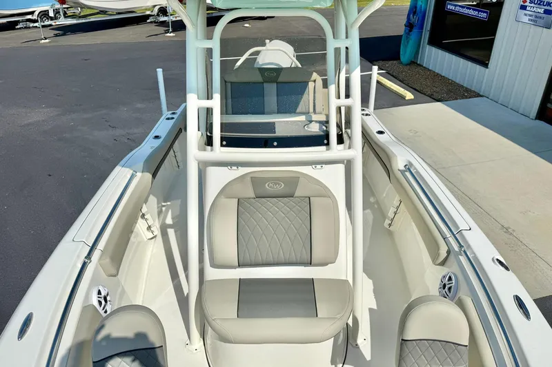Slide: The Image of 2026 Key West 219 FS boat interior with seating and console, parked outside a marine shop. - 23
