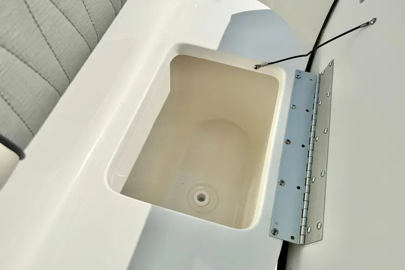 Slide: The Image of 2026 Key West 219 FS boat storage compartment with open lid and cushioned seating. - 26