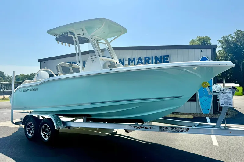 Slide: The Image of 2026 Key West 219 FS boat on trailer outside marine dealership. - 4