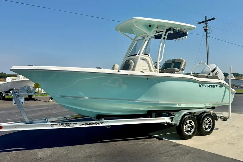 Slide: The Image of 2026 Key West 219 FS boat on trailer, light blue hull, parked outdoors. - 5