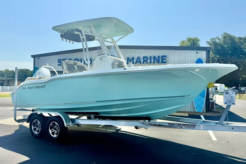 Slide: The Image of 2026 Key West 219 FS boat on trailer at dealership, sunny day. - 6