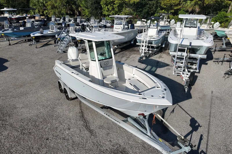 Slide: The Image of 2026 Sailfish 232 CC boat on trailer in a marina with multiple boats. - 5