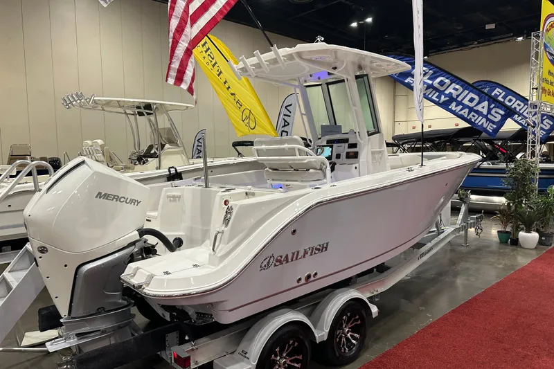 Slide: The Image of 2026 Sailfish 232 CC boat displayed indoors with Mercury engine and American flag. - 6