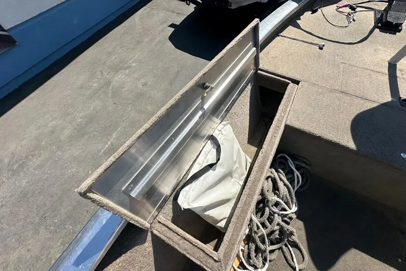 Slide: The Image of Open storage compartment on 2001 Bass Tracker Pro Team 175 boat with rope and bag. - 28