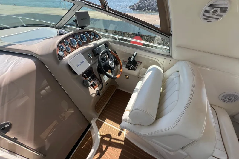 Slide: The Image of 2001 Sea Ray 290 Sundancer cockpit with steering wheel, gauges, and leather seating. - 11