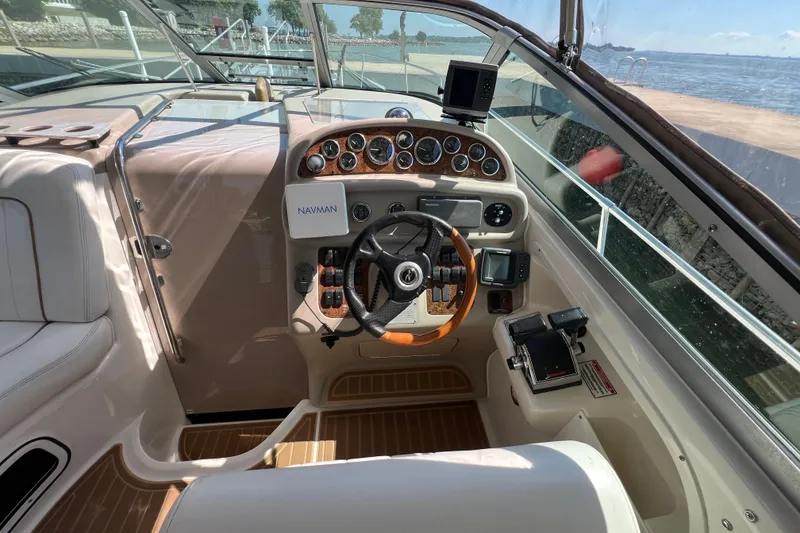 Slide: The Image of 2001 Sea Ray 290 Sundancer cockpit with steering wheel, gauges, and navigation equipment. - 12