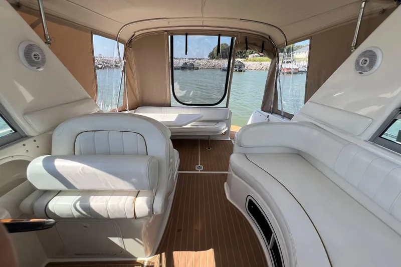 Slide: The Image of Interior of 2001 Sea Ray 290 Sundancer boat with white seating and wood flooring. - 13