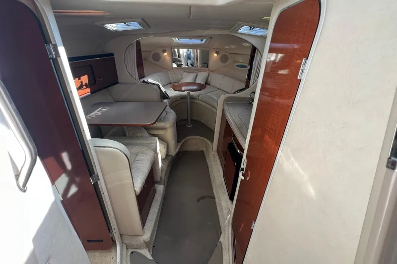 Slide: The Image of 2001 Sea Ray 290 Sundancer cabin interior with seating, table, and wood accents. - 14