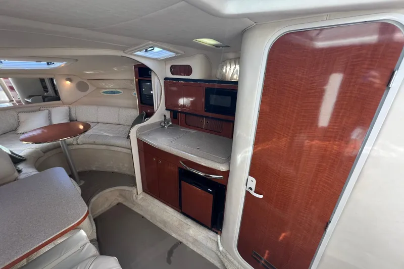 Slide: The Image of Interior of 2001 Sea Ray 290 Sundancer yacht with kitchenette and seating area. - 15