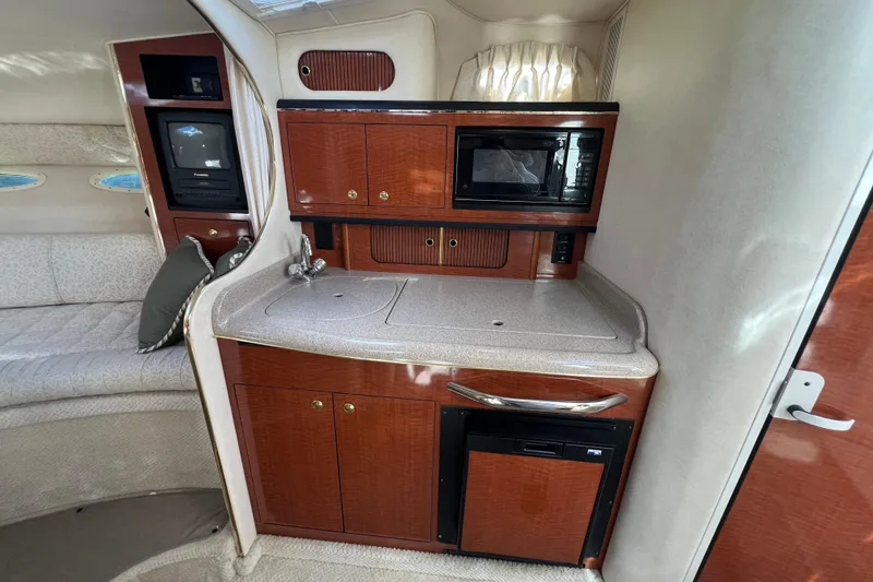 Slide: The Image of Interior of 2001 Sea Ray 290 Sundancer with kitchenette, microwave, and seating area. - 16