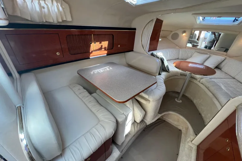 Slide: The Image of Interior of 2001 Sea Ray 290 Sundancer with cozy seating and wooden cabinetry. - 17
