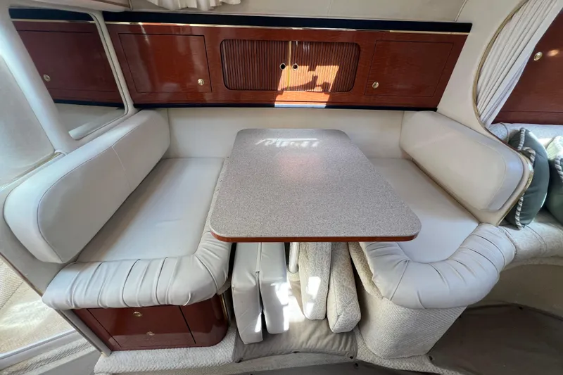Slide: The Image of Interior of 2001 Sea Ray 290 Sundancer with cozy seating and wooden cabinetry. - 18