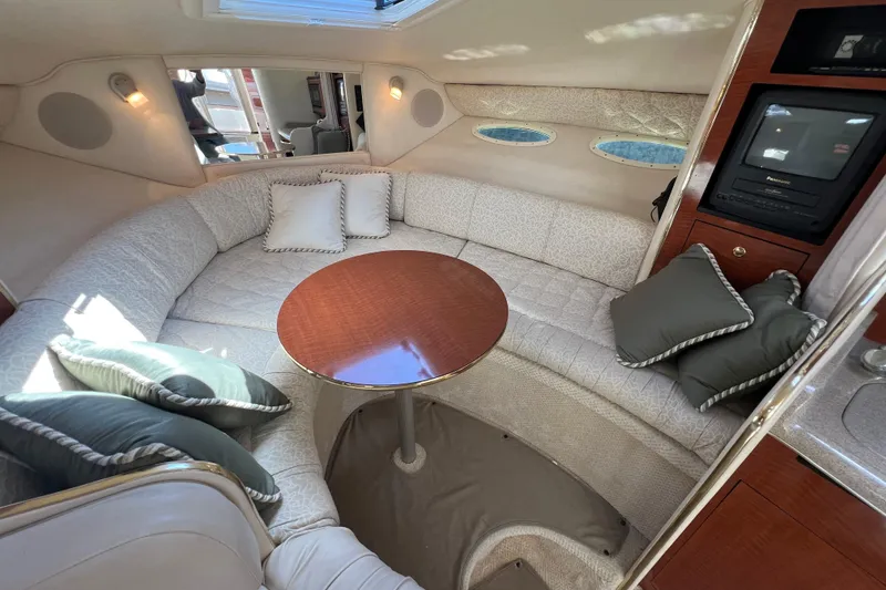 Slide: The Image of Interior of 2001 Sea Ray 290 Sundancer with cozy seating and wooden table. - 19