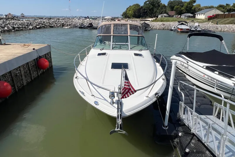 Slide: The Image of 2001 Sea Ray 290 Sundancer docked at marina with American flag. - 2
