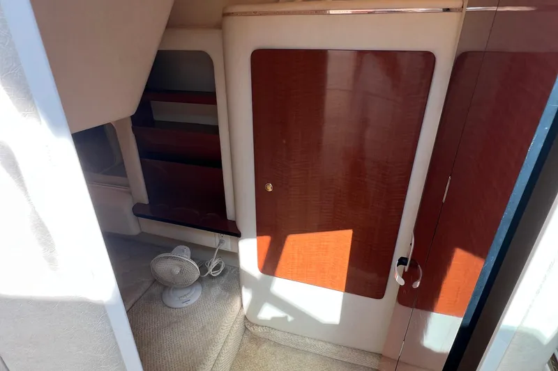 Slide: The Image of Interior of 2001 Sea Ray 290 Sundancer with wooden cabinetry and small fan. - 20