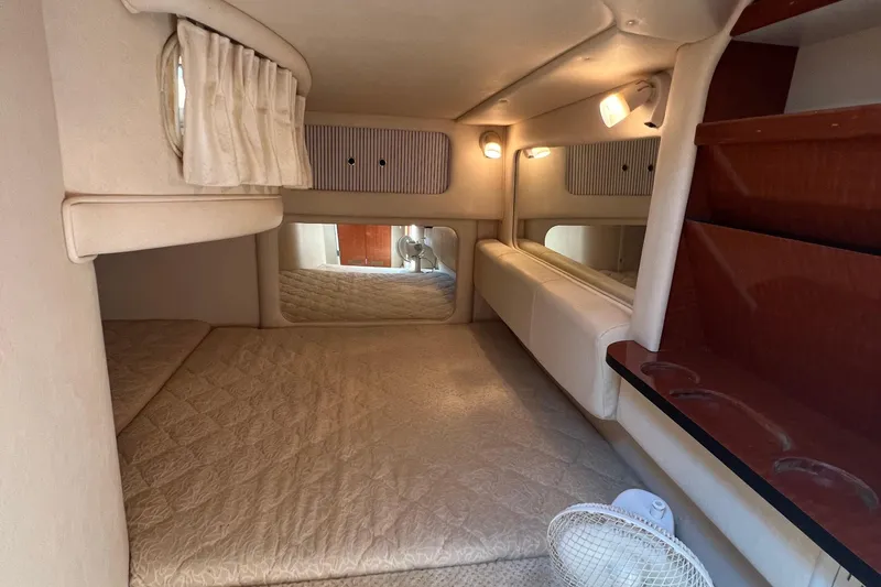 Slide: The Image of 2001 Sea Ray 290 Sundancer cabin interior with cozy sleeping area and ambient lighting. - 21
