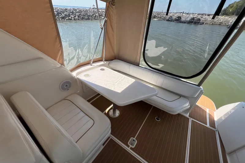 Slide: The Image of Interior of 2001 Sea Ray 290 Sundancer with seating and table, overlooking water. - 8