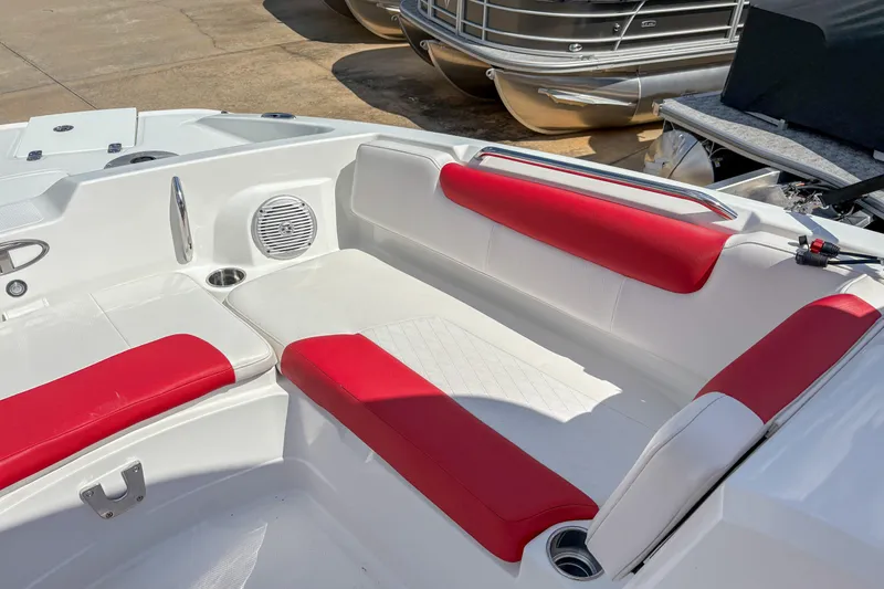 Slide: The Image of 2019 Tahoe 2150 boat interior with red and white seating, docked near other boats. - 12