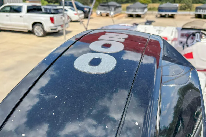 Slide: The Image of Close-up of a 2019 Tahoe 2150 boat engine with vehicles in the background. - 17