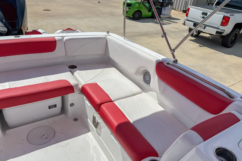 Slide: The Image of 2019 Tahoe 2150 boat interior with red and white seating, docked outdoors. - 8