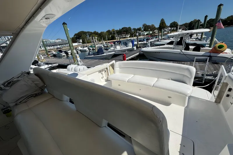 Slide: The Image of 2000 Tiara Yachts 3500 Express at marina, featuring spacious seating and docked boats. - 13