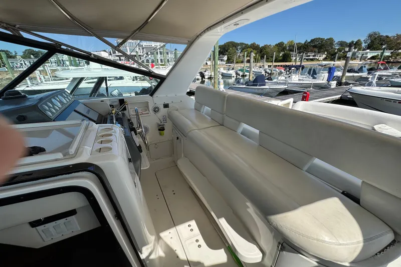 Slide: The Image of Interior view of 2000 Tiara Yachts 3500 Express, featuring helm and seating area at marina. - 14