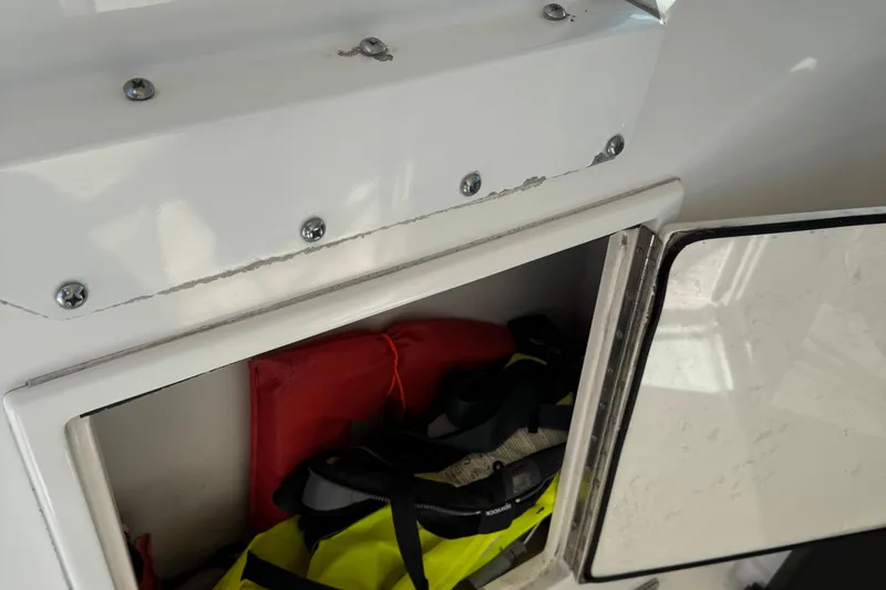 Slide: The Image of Open storage compartment on 2000 Tiara Yachts 3500 Express, containing life jackets and gear. - 23