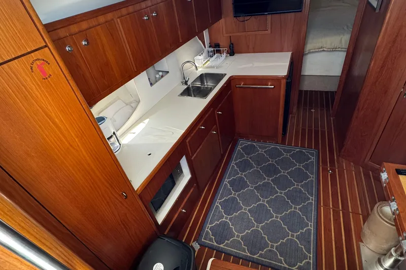 Slide: The Image of Interior of 2000 Tiara Yachts 3500 Express, featuring a wooden galley with modern amenities. - 28