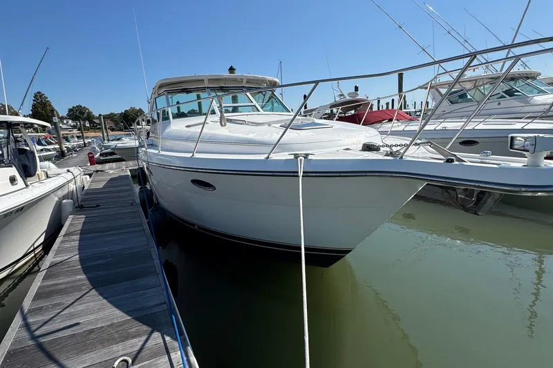 Slide: The Image of 2000 Tiara Yachts 3500 Express docked at marina under clear blue sky. - 3