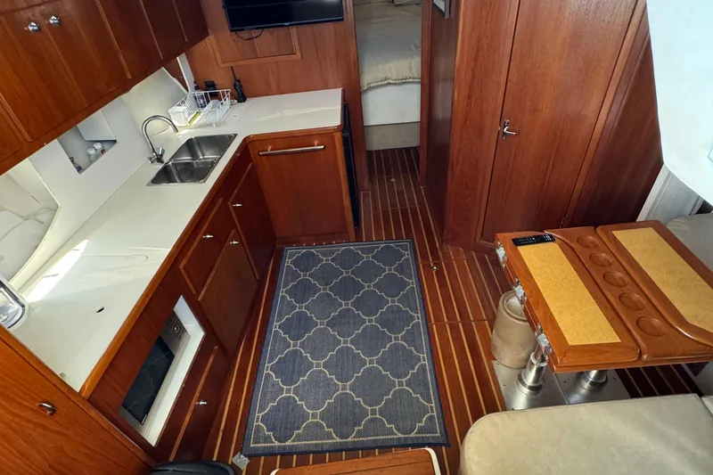 Slide: The Image of Interior of 2000 Tiara Yachts 3500 Express with wood cabinetry and compact kitchen. - 30