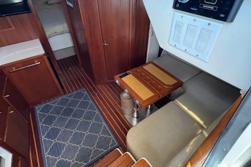 Slide: The Image of Interior of 2000 Tiara Yachts 3500 Express with wood accents and seating area. - 31