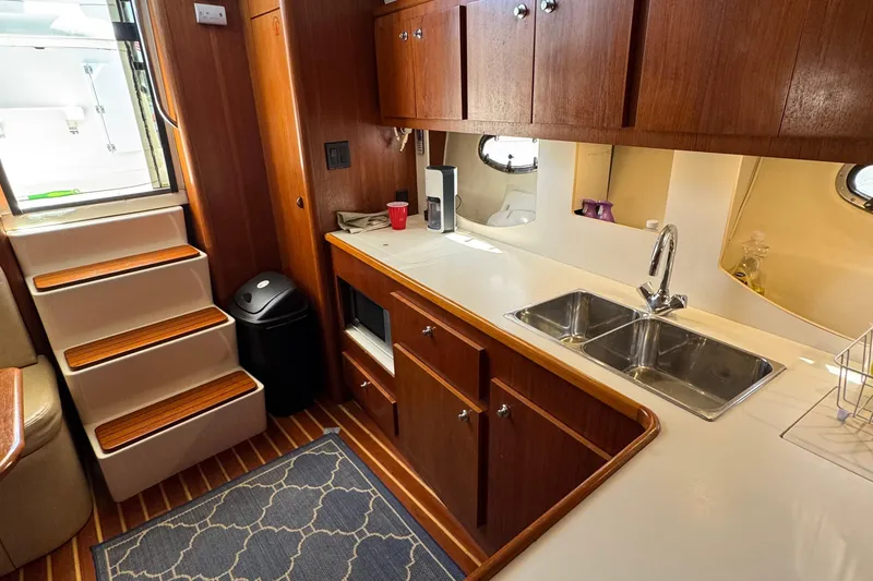 Slide: The Image of Interior of 2000 Tiara Yachts 3500 Express, featuring a wooden kitchen with dual sinks. - 33