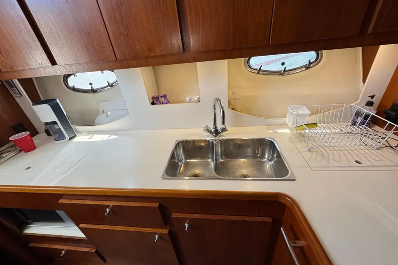 Slide: The Image of Interior of 2000 Tiara Yachts 3500 Express, featuring a well-equipped kitchen area. - 34