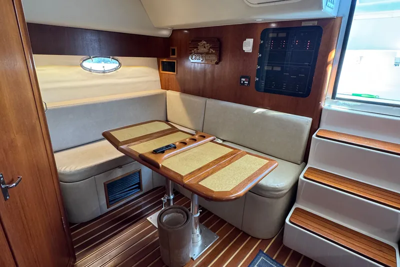 Slide: The Image of Interior of 2000 Tiara Yachts 3500 Express with wooden table and seating area. - 35