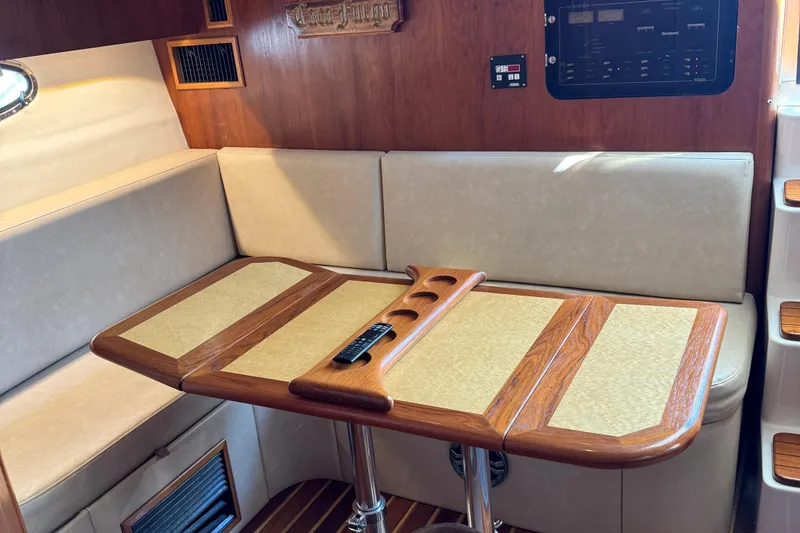 Slide: The Image of Interior of 2000 Tiara Yachts 3500 Express with wooden table and beige seating. - 36