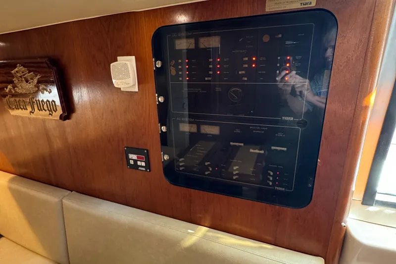 Slide: The Image of Control panel inside 2000 Tiara Yachts 3500 Express, featuring wood paneling and seating. - 40