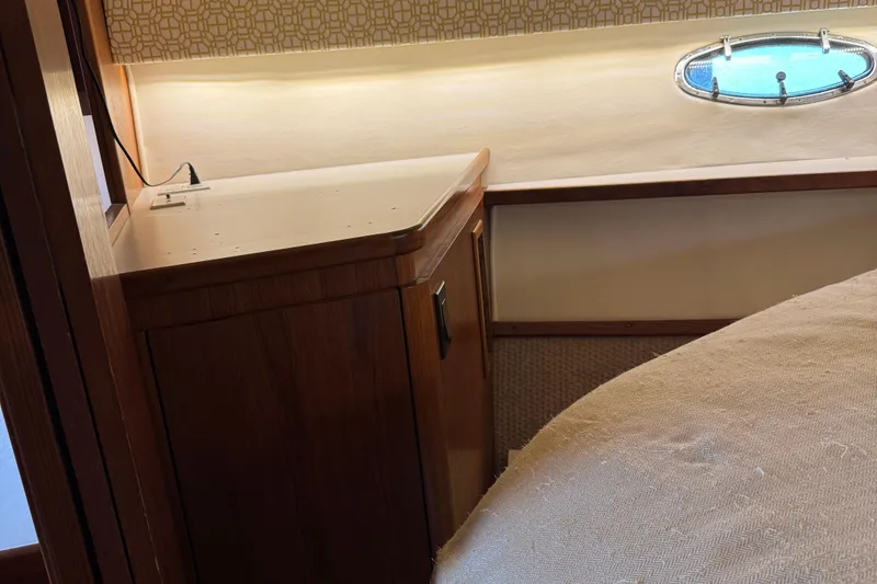 Slide: The Image of Interior of 2000 Tiara Yachts 3500 Express, featuring wood cabinetry and a porthole window. - 46