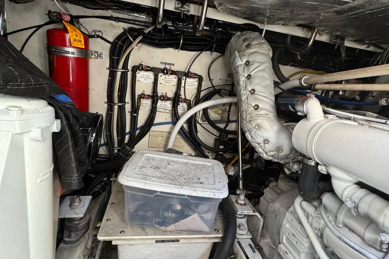 Slide: The Image of Engine room of a 2000 Tiara Yachts 3500 Express, featuring mechanical components and fire extinguisher. - 51