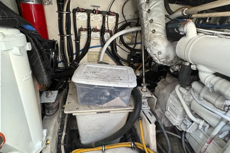 Slide: The Image of Engine room of a 2000 Tiara Yachts 3500 Express, featuring mechanical components and wiring. - 54