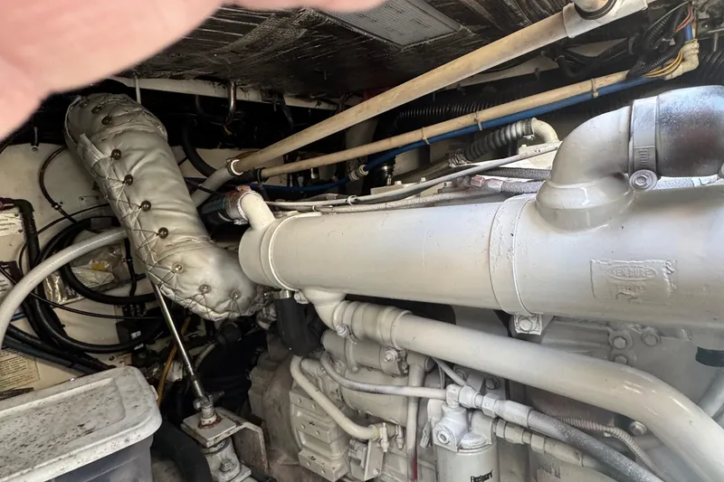 Slide: The Image of Engine compartment of a 2000 Tiara Yachts 3500 Express, showcasing mechanical components and piping. - 56