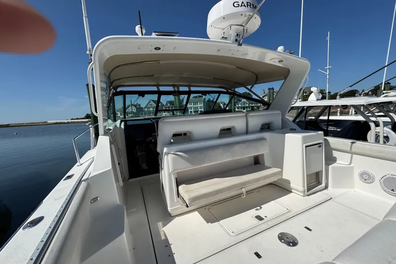 Slide: The Image of 2000 Tiara Yachts 3500 Express boat interior with seating, docked by calm waters. - 9