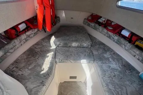Slide: The Image of 1996 Grady-White Voyager 248 cabin interior with cushioned seating and life jackets. - 10