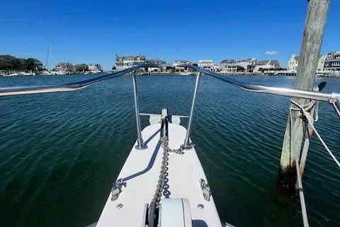 Slide: The Image of Bow view of 1996 Grady-White Voyager 248 boat in a serene harbor. - 18