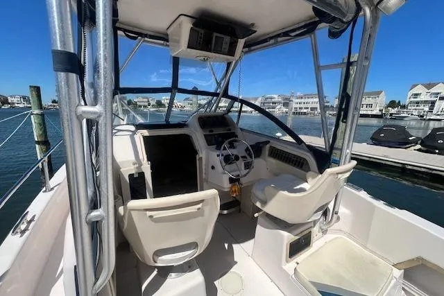 Slide: The Image of 1996 Grady-White Voyager 248 boat interior with helm, seats, and marina view. - 7